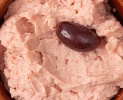 Eine Kugel rosa Tarama mit Oliven und Brot.
