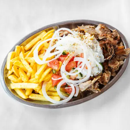 Gyros Teller (Mittel) mit Zwiebeln, Tomaten, Gurken & Beilage nach Wahl – serviert mit Sauce auf einem Teller.