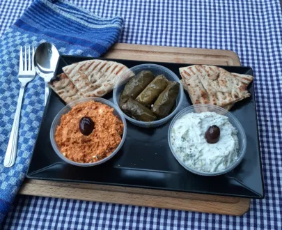 Meze Trio Classic – Tzatziki, Kopanisti, Weinblätter & Pitabrot, serviert als authentische griechische Vorspeise.