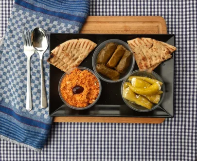 Meze Trio Scharf – Kopanisti, gefüllte Peperoni, Weinblätter & Pitabrot – pikante griechische Vorspeisenplatte.