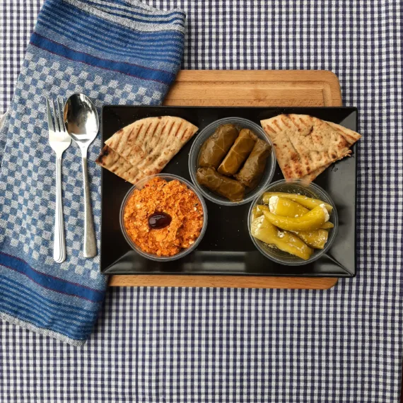 Meze Trio Scharf – Kopanisti, gefüllte Peperoni, Weinblätter & Pitabrot – pikante griechische Vorspeisenplatte.